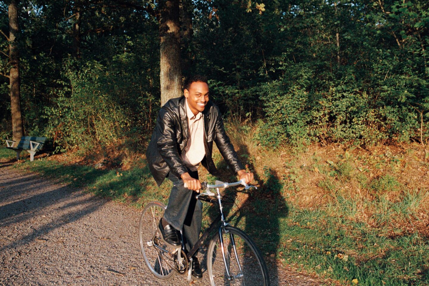 Glad ung man cyklar på skogsstig.