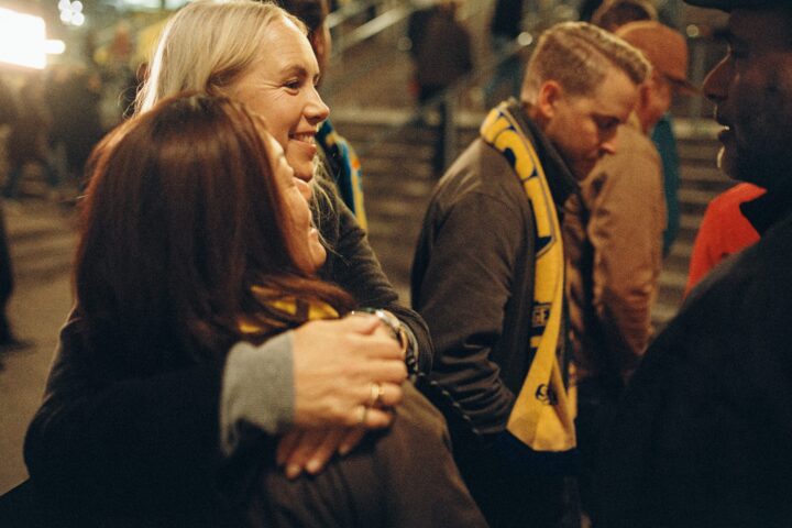 Två kvinnliga svenska fans kramar om varandra,