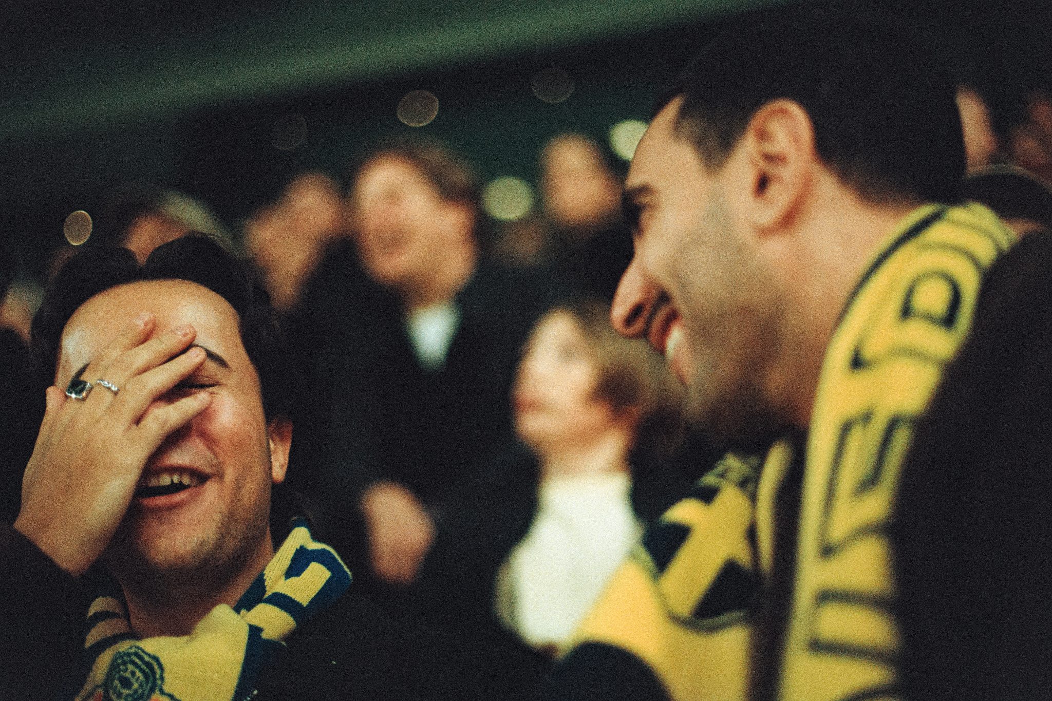 Två glada och uppspelta svenska fans på idrottsläktare.