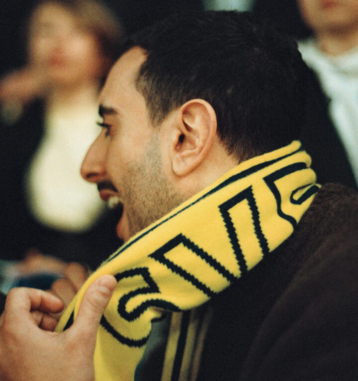 Glad man på läktare iförd Sverige-halsduk.