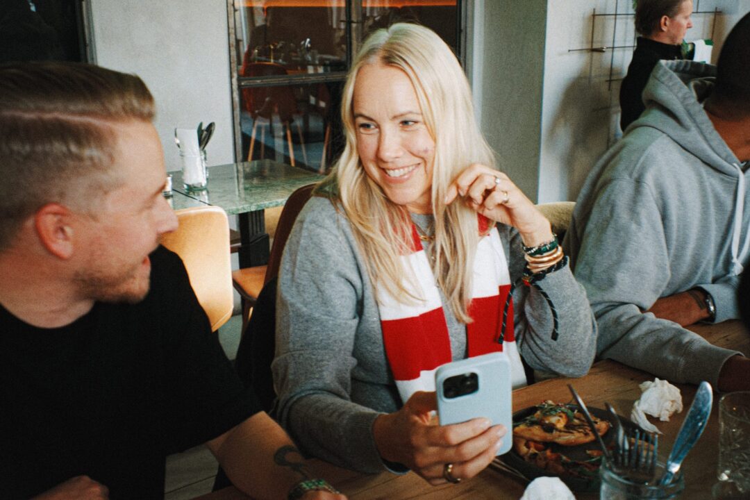 Man och kvinna ler vid restaurangbord.